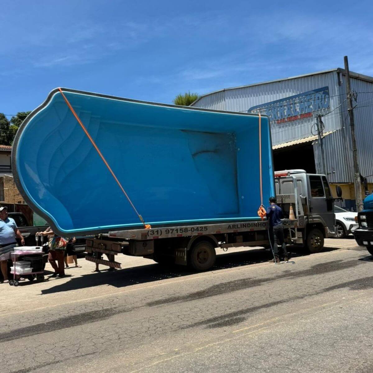 Logística de transporte de piscina de fibra azul de grande porte.