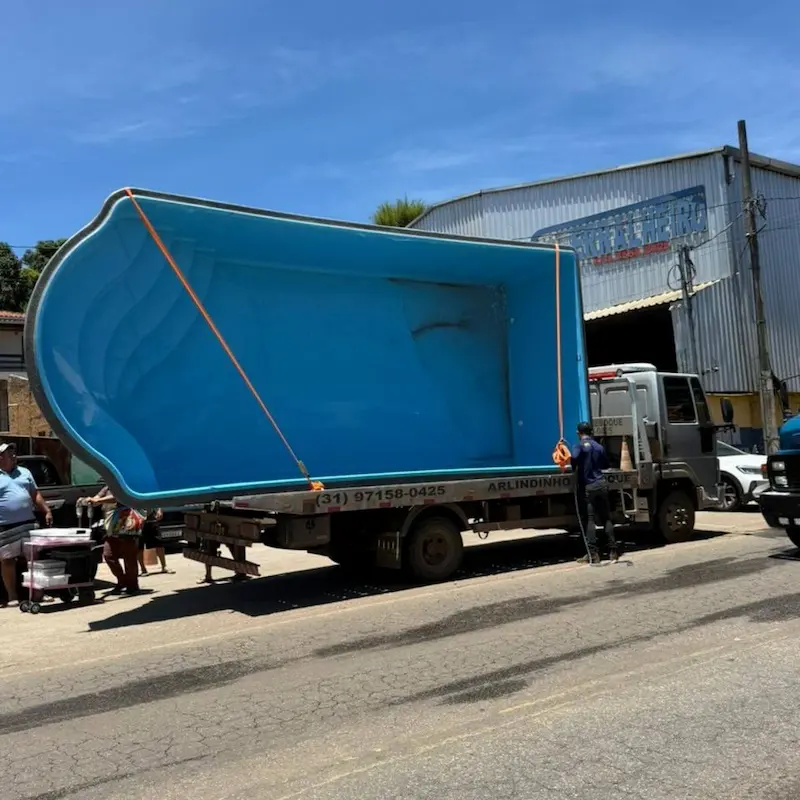 Logística de transporte de piscina de fibra azul de grande porte.